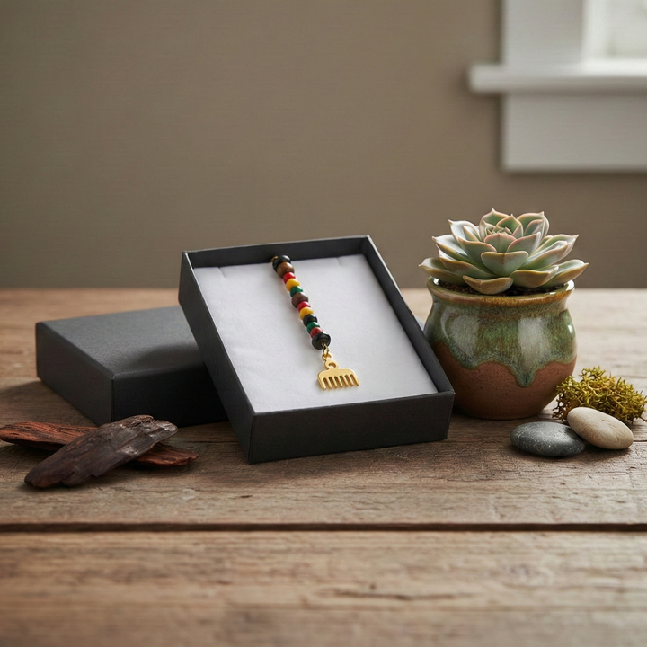 Decorative elements in a black box on a wooden surface with a plant and stones.